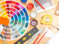 Professional decorator drawing on a house project with work tools